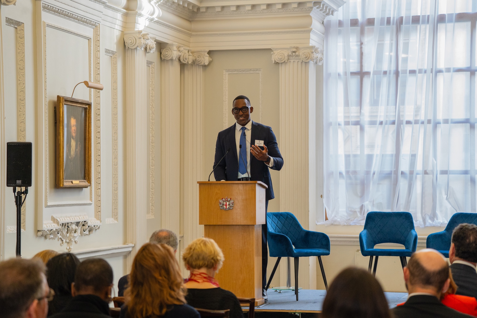Kwaku Kyei-Manu delivering a keynote from the lectern at Mansion House.